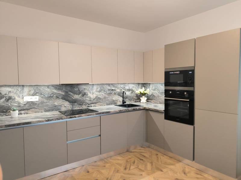 Kuchyně ve 4pokojovém bytě s mramorovou pracovní deskou a podlahou s dřevěným dekorem.