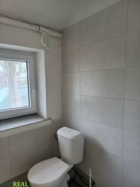 Toaleta s obklady na stěně ve výrobních prostorách.