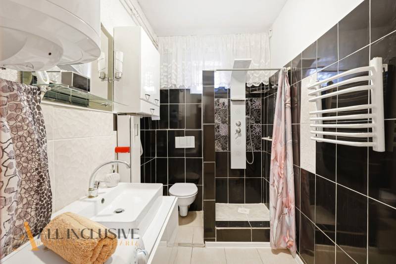 Koupelna se sprchovým koutem, umyvadlem a zrcadlem v rodinném domě.