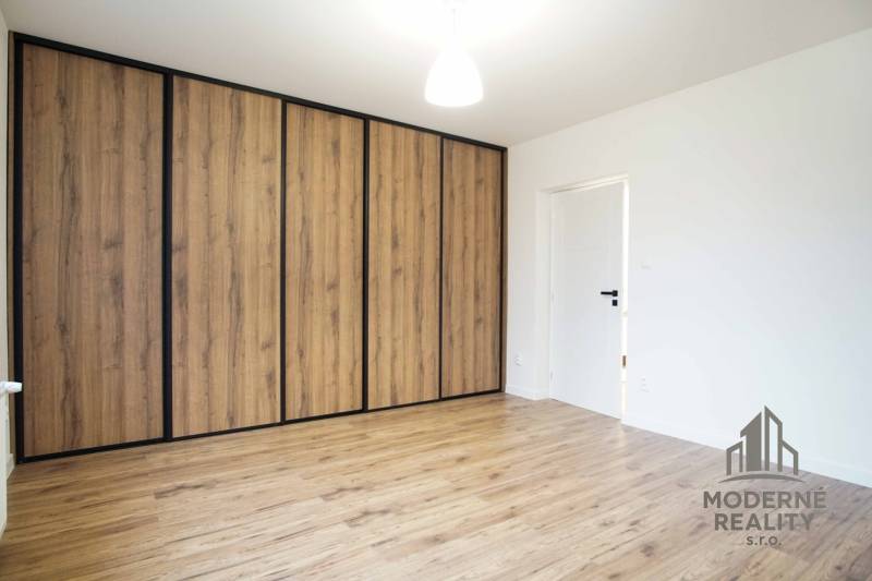 Pokoj v rodinném domě s podlahou s dřevěným dekorem a skříní.