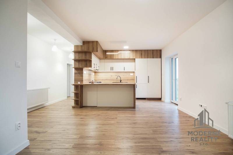 Kuchyně v rodinném domě s podlahou s dřevěným dekorem a bílými skříňkami.