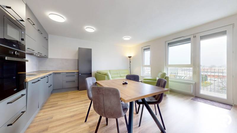 Kuchyně s podlahou s dřevěným dekorem a jídelním stolem ve 3-pokojovém bytě.