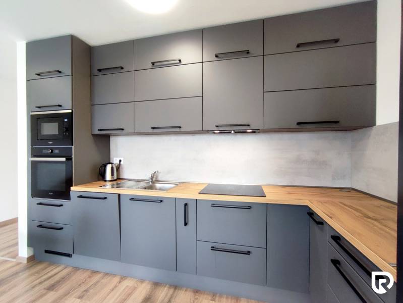 Stylová kuchyně v 3-pokojovém bytě s podlahou s dřevěným dekorem a šedými skříňkami.