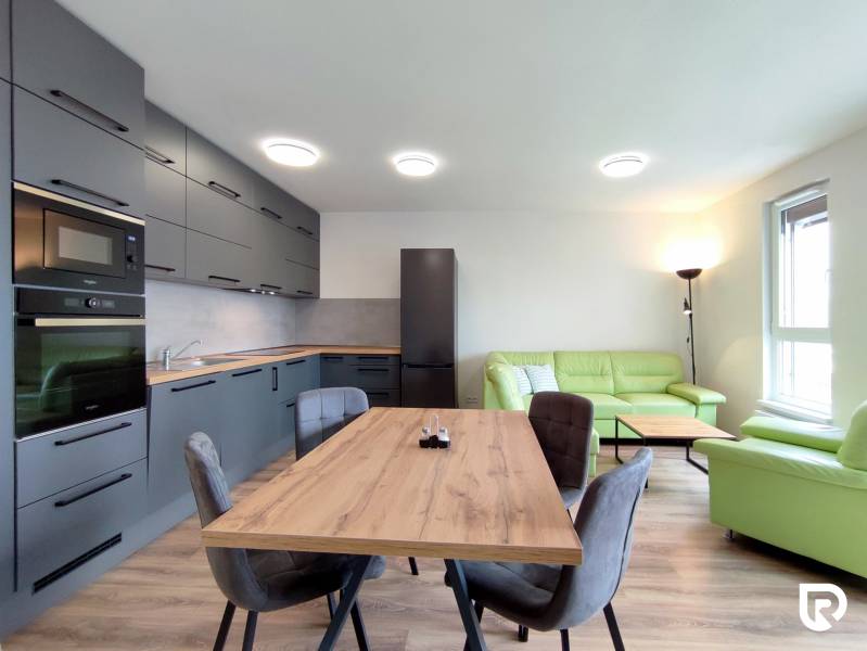 Světlá kuchyně s jídelním stolem a pohovkou ve 3-pokojovém bytě s podlahou s dřevěným dekorem.