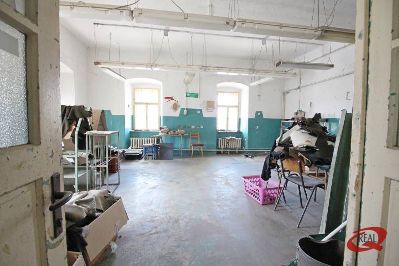 Opuštěná místnost v budově s bílými stěnami a modrými detaily.