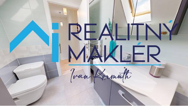 Koupelna v rodinném domě s toaletou, umyvadlem a dlažbou.