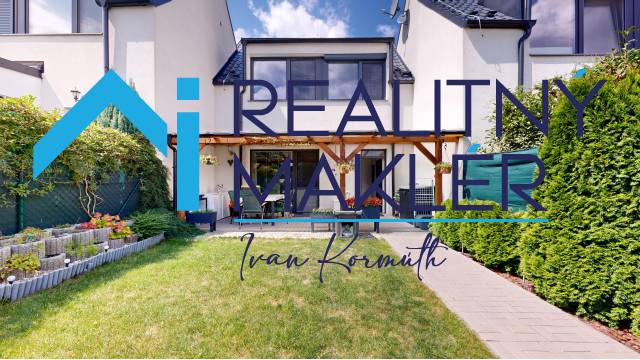 Zahrada a terasa u rodinného domu ve Stupavě s upraveným trávníkem a záhonem.