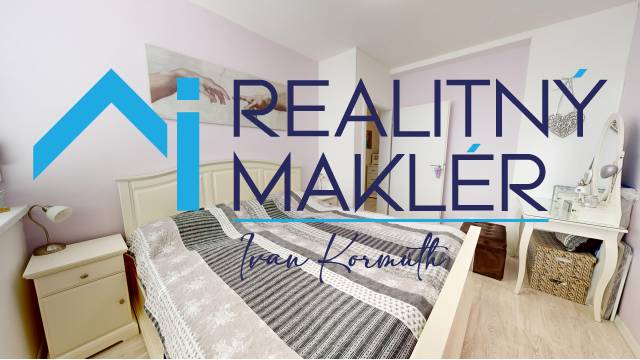 Ložnice v rodinném domě s dekorativním textilem a podlahou s dřevěným dekorem.