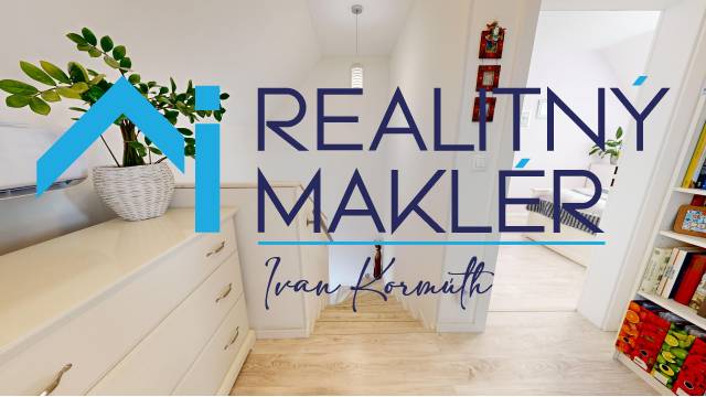 Interiér rodinného domu s podlahou s dřevěným dekorem a světlým nábytkem.