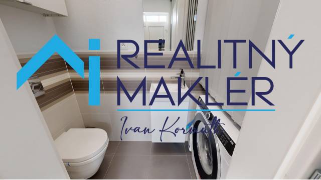 Koupelna s toaletou a pračkou v rodinném domě, světlé obklady a dlažba.