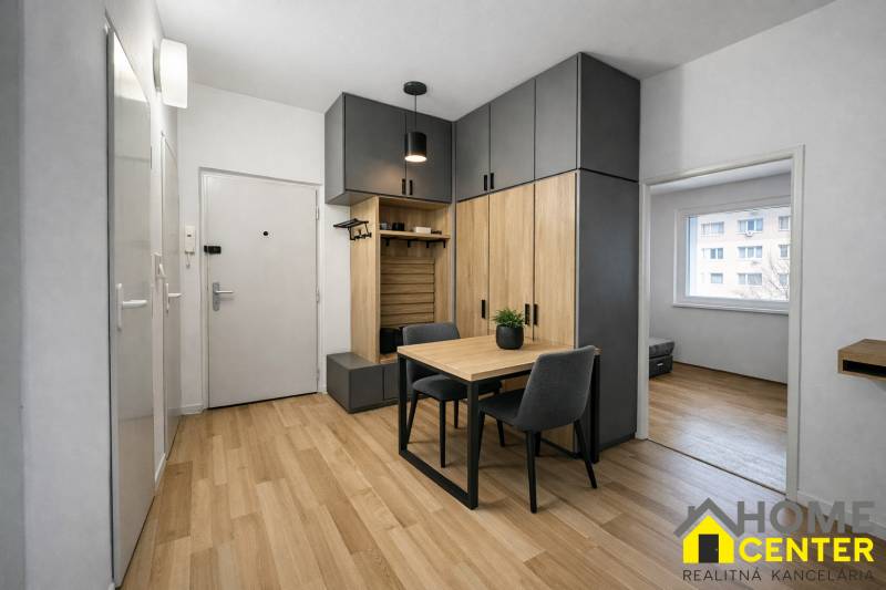 Předsíň 3pokojového bytu s podlahou s dřevěným dekorem a vestavěnými skříněmi.