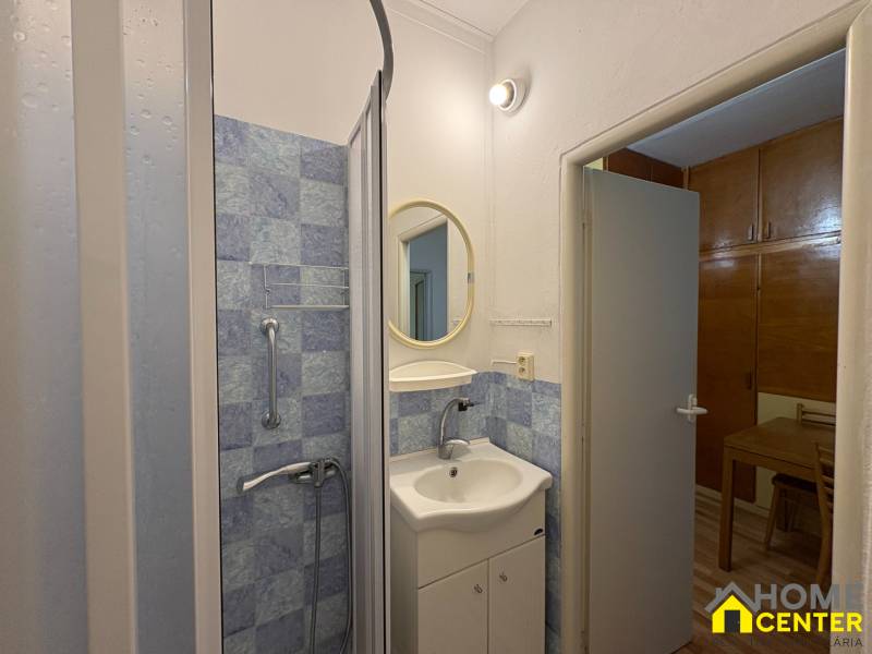 Koupelna v 3-pokojovém bytě s modrými obklady a sprchovým koutem.