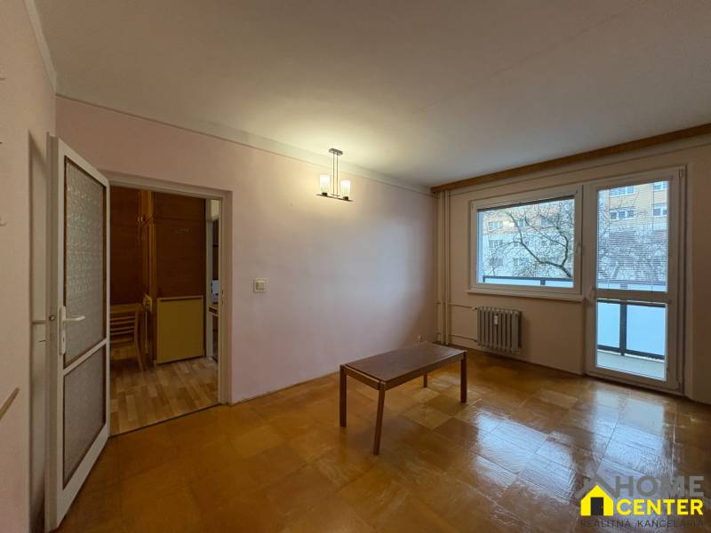 3-pokojový byt s podlahou s dřevěným dekorem, stůl, balkónové dveře.