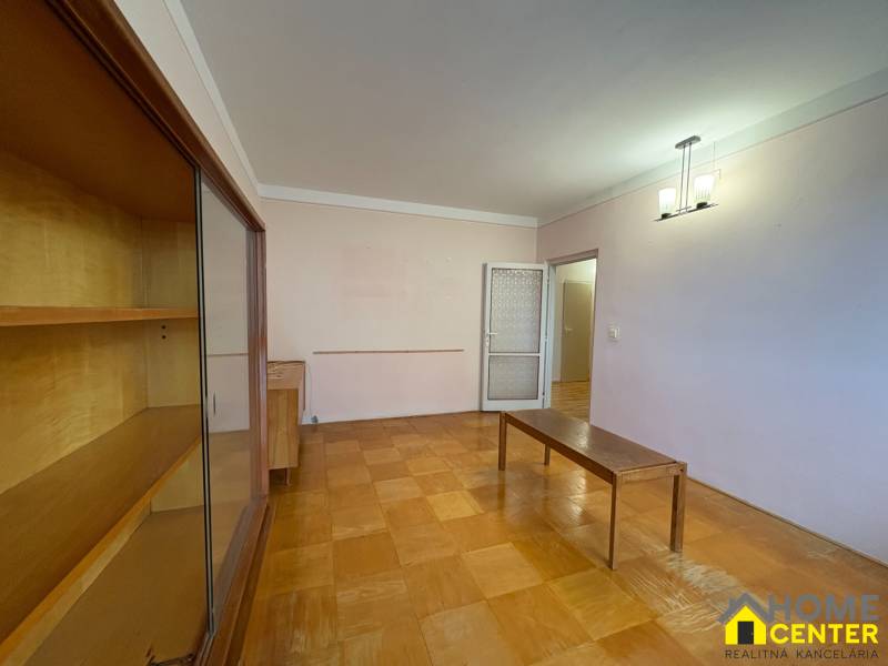 Obývací pokoj v 3-pokojovém bytě s podlahou s dřevěným dekorem a nábytkem.