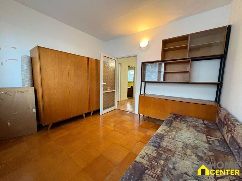 Pokoj v 3-pokojovém bytě s nábytkem ze dřeva a podlahou s dřevěným dekorem.