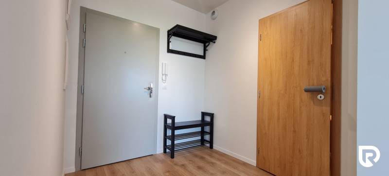 Vstupní předsíň s věšákem v 2-pokojovém bytě. Dřevěný dekor podlahy.