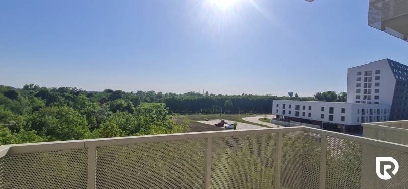 Výhled z balkonu v Bratislavě - Ružinov na Ivanské cestě s budovami a zelení.