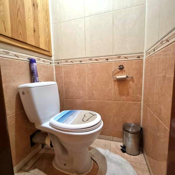 Koupelna v 2-pokojovém bytě s keramickými obklady a toaletou.