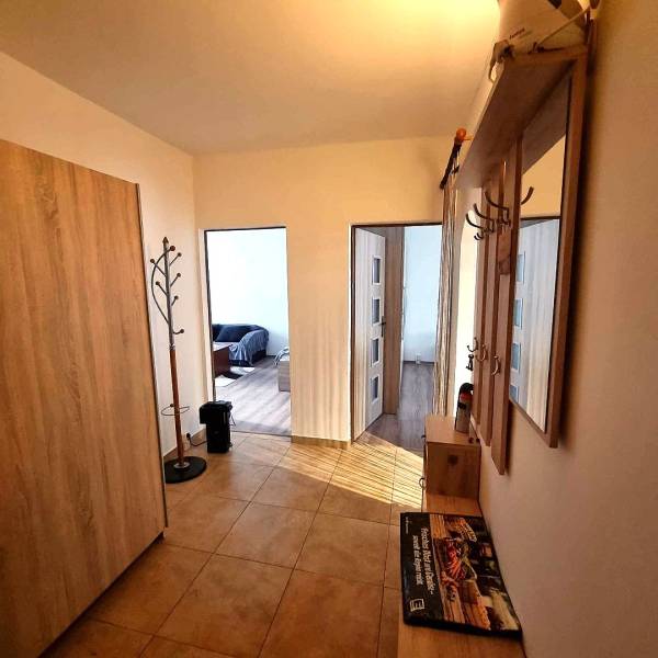 Chodba v 2-pokojovém bytě s věšákem a podlahou s dřevěným dekorem.