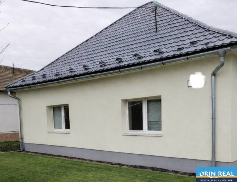 Rodinný dům na Trnavské ulici v Bernolákově, se šikmou střechou a zahradou.