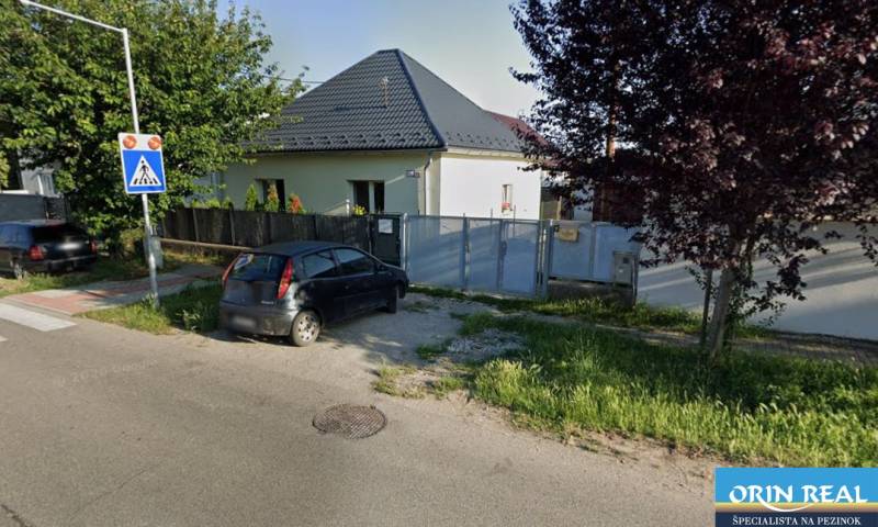 Rodinný dům na Trnavské ulici v Bernolákově s autem zaparkovaným před bránou.