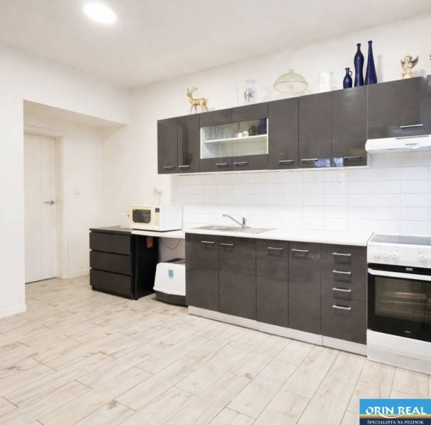 Kuchyně s tmavými skříňkami, podlaha s dřevěným dekorem, rodinný dům.