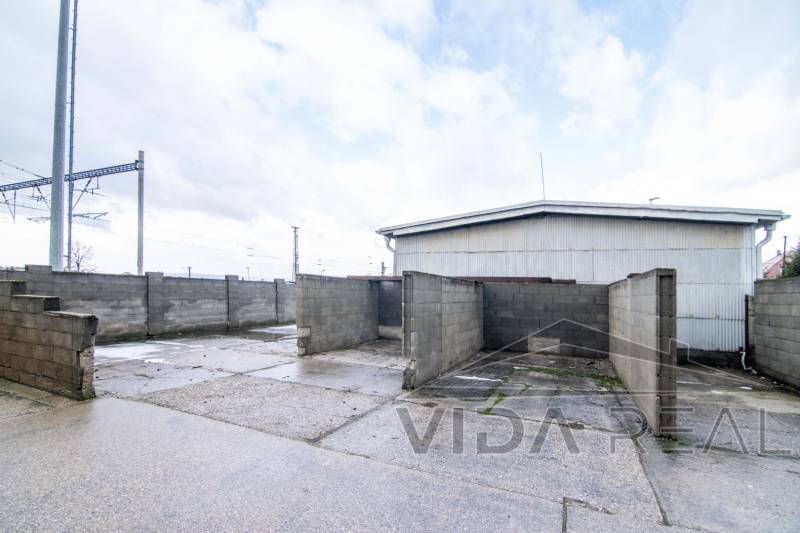 V Šenkvicích na Nádražní ulici jsou na fotografii zobrazeny sklady a haly s pevnými betonovými stěnami.