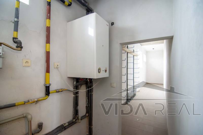 Interiér se spotřebičem a trubkami v prostorách Sklady a haly.