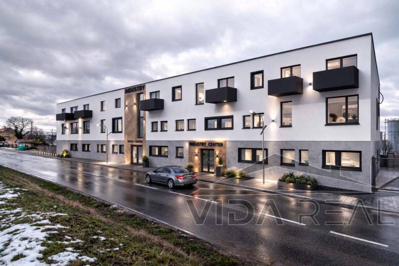 Budova na Nádražní ulici v Šenkvicích, sklady a haly, s večerním osvětlením.