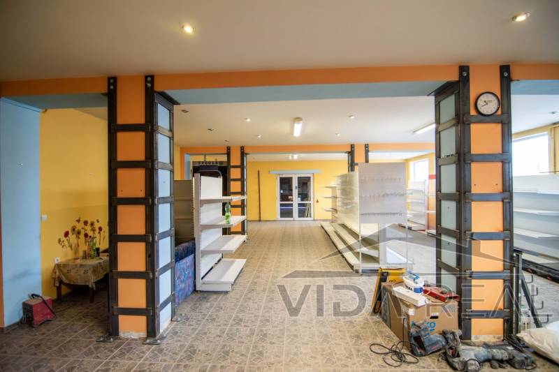 Interiér skladu s regály a květinovým motivem na stěně, Sklady a haly.