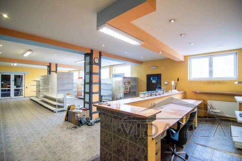 Interiéry skladů a hal s vstupní recepcí, regály a osvětlením.