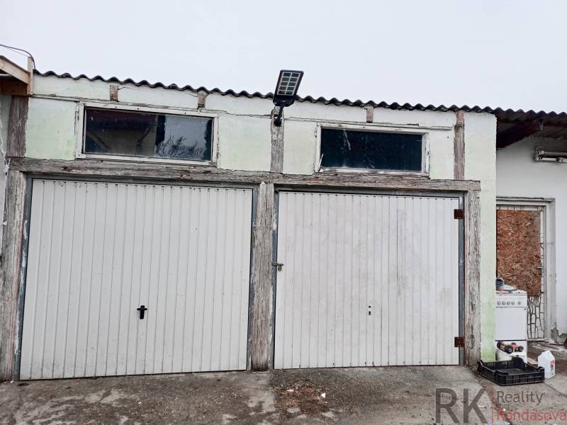 Garáž se dvěma roletovými dveřmi a solárním panelem u rodinného domu ve Vizsoly.