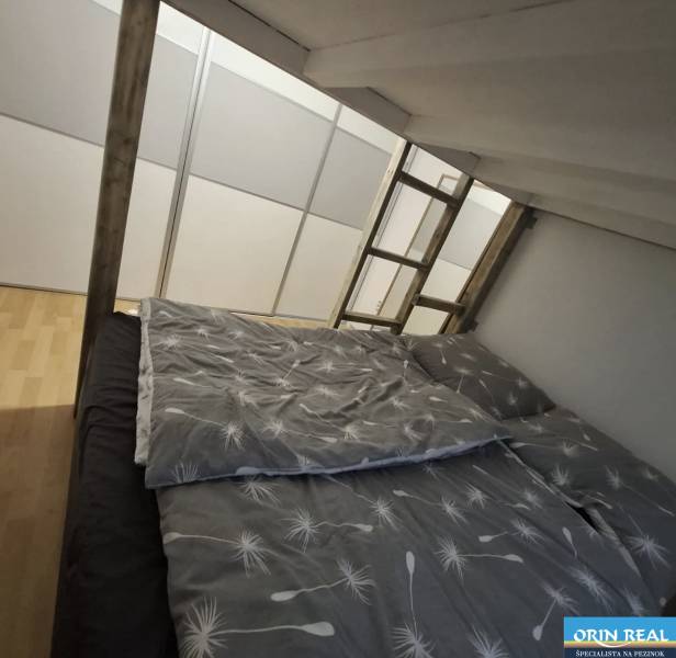 Ložnice v 2-pokojovém bytě s podlahou s dřevěným dekorem a palandou.