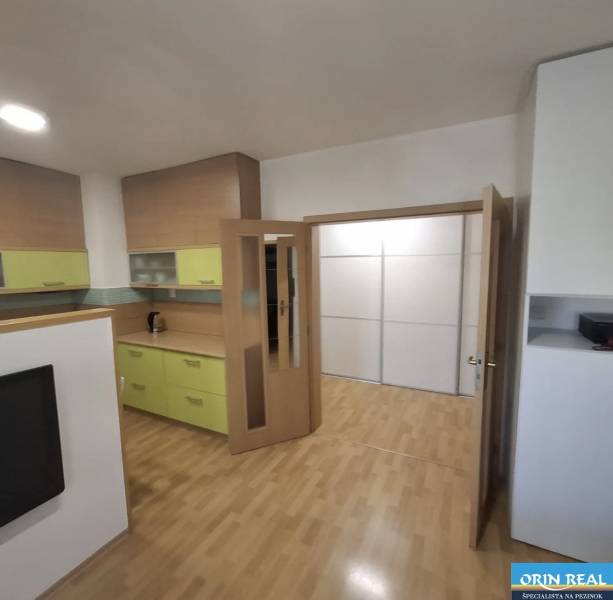 Interiér 2-pokojového bytu s podlahou s dřevěným dekorem a světlým nábytkem.