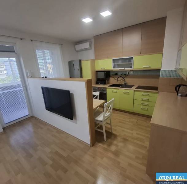 Kuchyně v 2-pokojovém bytě s podlahou s dřevěným dekorem a světlou linkou.