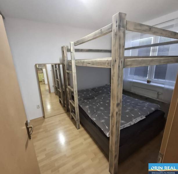 Dřevěná patrová postel v 2pokojovém bytě s podlahou s dřevěným dekorem.