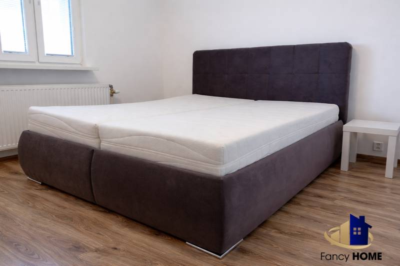 Ložnice s postelí a podlahou s dřevěným dekorem ve 3-pokojovém bytě.