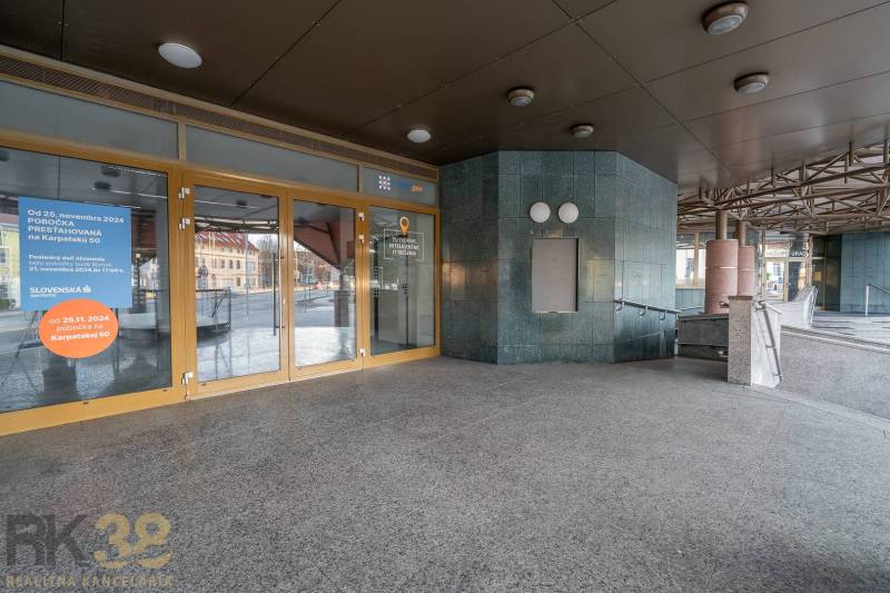 Vstup do kanceláří v Popradu se skleněnými dveřmi a schodištěm.