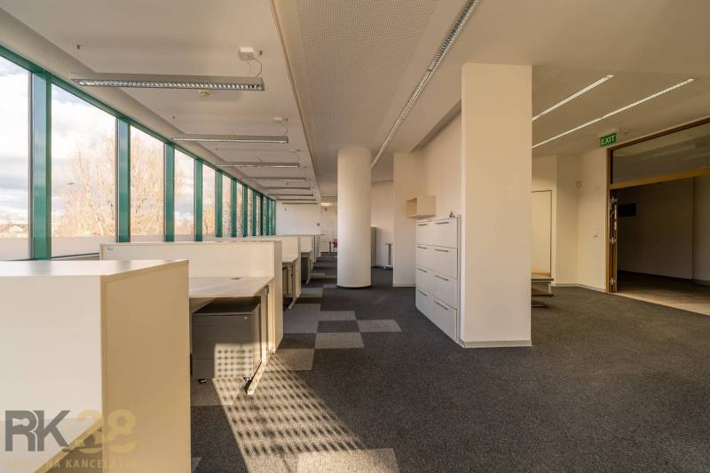 Světlé kanceláře s velkými okny a kancelářským nábytkem, podlaha s dřevěným dekorem.