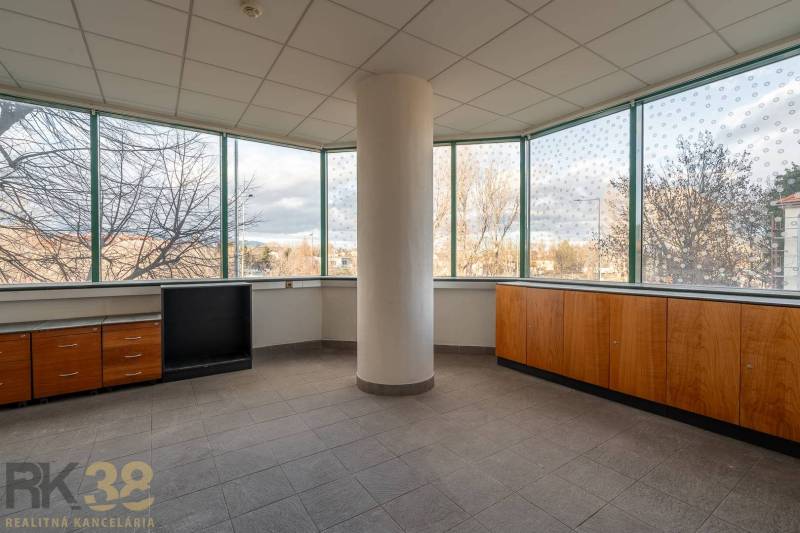 Prostorné kanceláře s velkými okny a výhledem na město, podlaha dlaždicová.