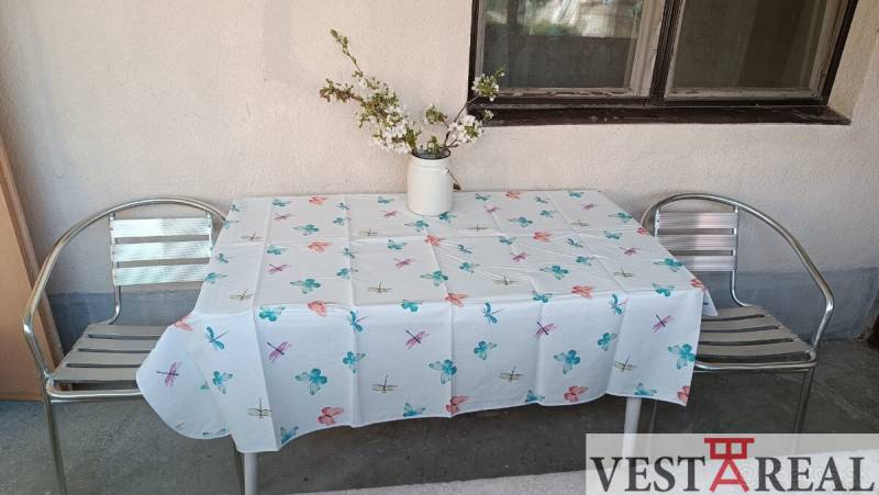 Terasa rodinného domu v Horních Salibách se dvěma kovovými židlemi a stolem s ubrusem.