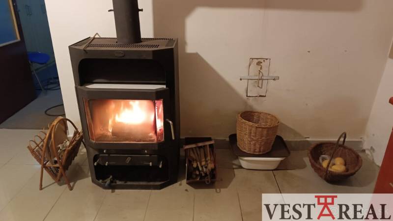 Rodinný dům s krbem, pletenými košíky a ohništěm na udržování tepla a atmosféry.