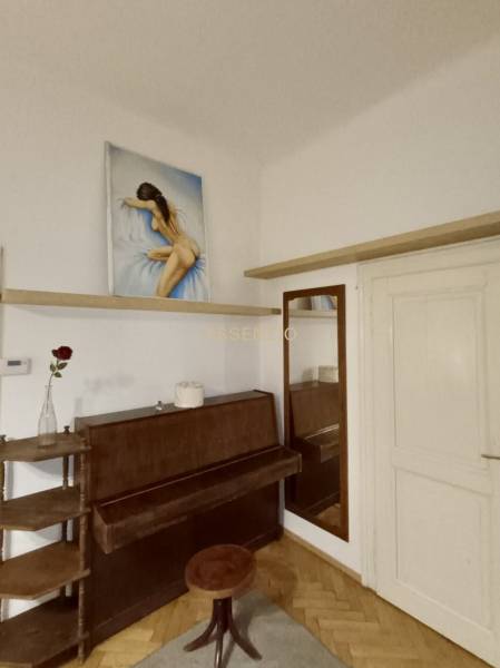 Interiér 3-pokojového bytu se zrcadlem, pianem a obrazem nad ním.