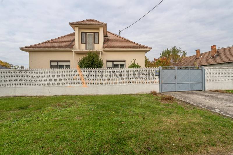 Rodinný dům ve Velkých Dvornících s plotem a udržovanou zahradou.