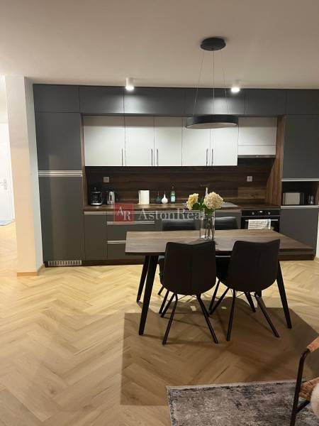 Kuchyně ve 3-pokojovém bytě se šedými skříňkami a podlahou s dřevěným dekorem.