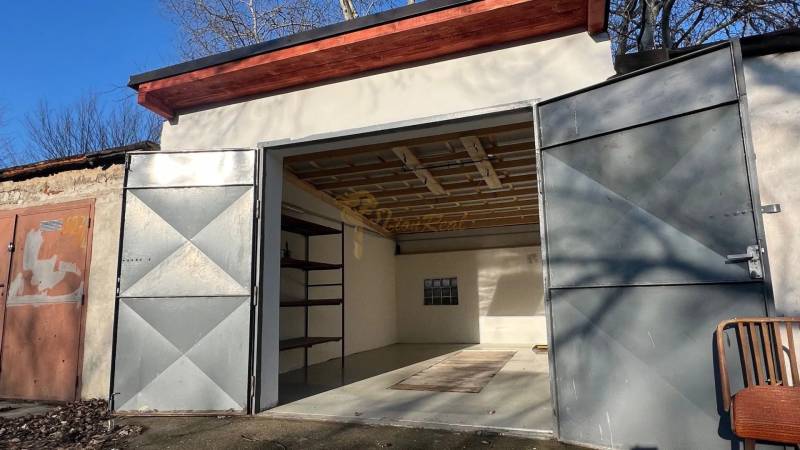 Otevřená garáž na Agátové v Bratislavě - Dúbravce s jednoduchým interiérem a regálem.