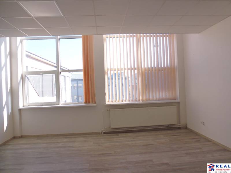 Prostorné kanceláře s velkými okny a podlahou s dřevěným dekorem.