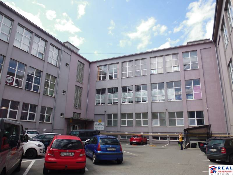 Budova s kancelářemi na Masarykově ulici v Prešově, před kterou jsou zaparkovaná auta.