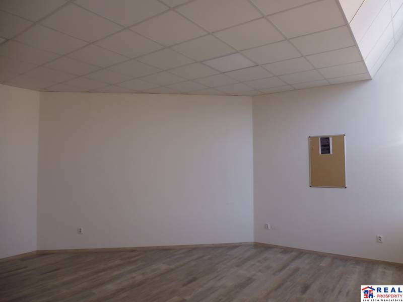 Místnost s podlahou s dřevěným dekorem a korkovou nástěnkou v kanceláři.