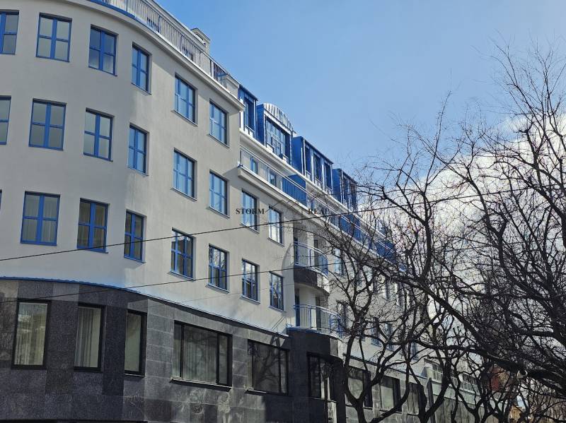 Budova v Bratislavě - Starém Městě na Poštové ulici se stromy v popředí.